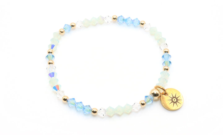 Bracelet with beads and a gold charm on a white background