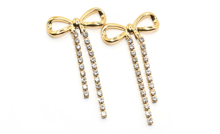 Gold bow-shaped earrings with rhinestone details on a white background