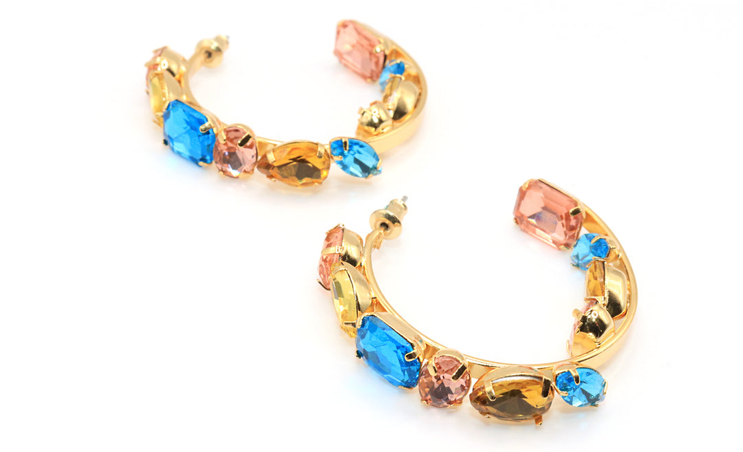 Gold hoop earrings with multicolored gemstones on a white background