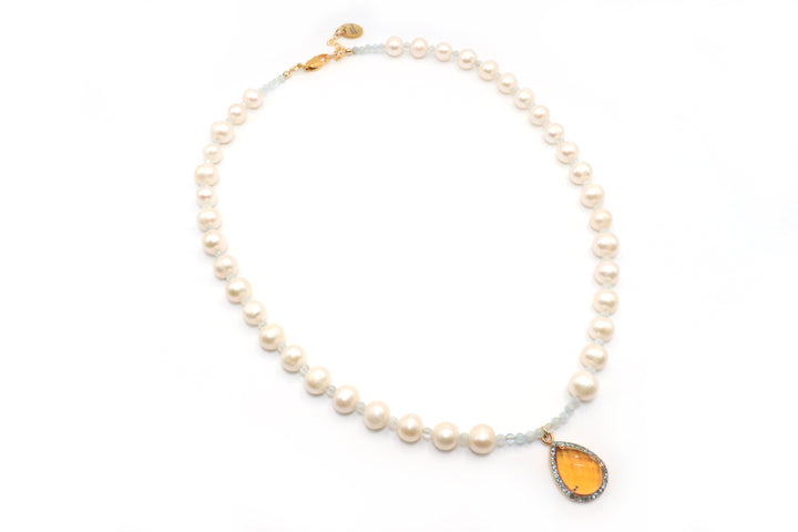 Pearl necklace with a teardrop-shaped citrrine pendant on a white background