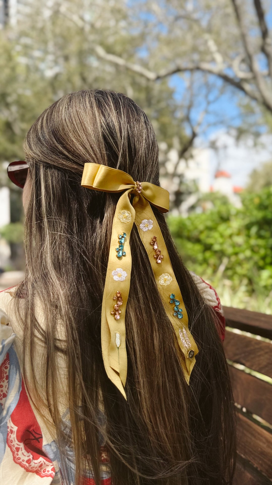 Person with a decorative hair ribbon in an outdoor setting