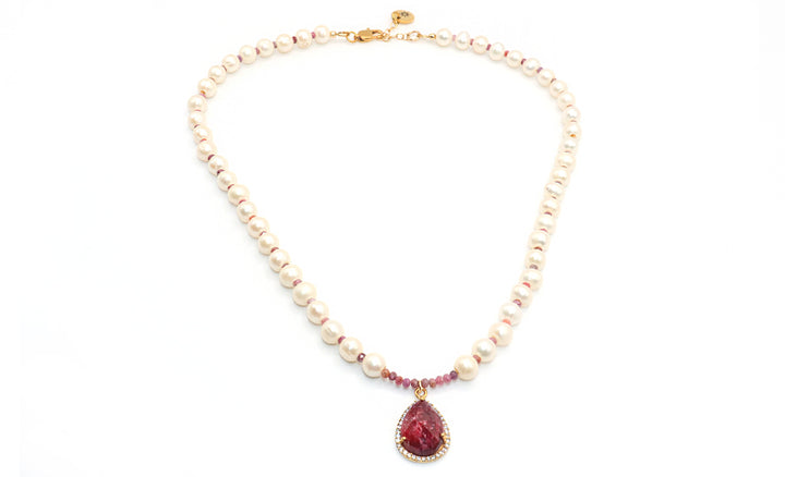 Pearl necklace with a red teardrop pendant on a white background