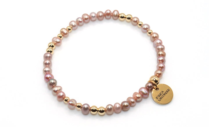 a bracelet with purple lavender pearls and gold beads
