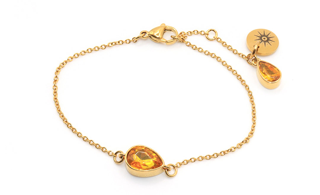 Gold bracelet with amber-colored teardrop charms on a white background